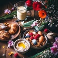 Rustic easter breakfast flat lay with eggs bagels, tulips, croissants, egg, oatmeal with berries, colored quail eggs