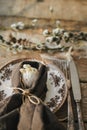 Rustic Easter table setting. Natural egg in napkin with flowers, setting with vintage plate, cutlery, pussy willow branches on