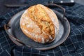 Rustic european spelt flour loaf of bread on iron tray