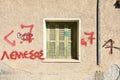 Rustic Faded Green Shutters with Red Graffiti