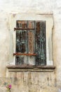 Rustic faded vintage wooden window shutter set in a stone wall