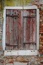 Rustic faded window with closed shutters in an old building in Venice, Italy
