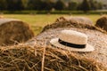 Photo landscape haystack rolls in the field with straw hat. Rustic farming concept. Summer day, sunset Royalty Free Stock Photo