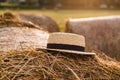 Photo landscape haystack rolls in the field with straw hat. Rustic farming concept. Summer day, sunset Royalty Free Stock Photo