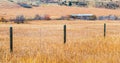 Rustic fence in a field of golden autumn grass in Montana Royalty Free Stock Photo