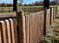 a rustic fence made of natural planks and posts sharpened to Royalty Free Stock Photo