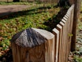 a rustic fence made of natural planks and posts sharpened to Royalty Free Stock Photo