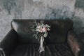 Rustic floral composition with light roses and other flowers on a luxury brown sofa.. Royalty Free Stock Photo