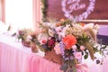 Rustic flower arrangement in a golden vase at a wedding banquet. Table set for an event party or wedding reception.