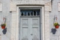 Rustic front door of a old cottage with vintage hardware and decorated with a basket of flowers Royalty Free Stock Photo