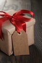 Rustic gift box with red ribbon bow and empty tag