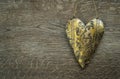 Rustic golden heart ornament on vintage wooden background