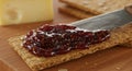 Rustic Gourmet Spreading Deep Purple Fig Jam on a Seeded Cracker Royalty Free Stock Photo