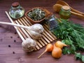 Rustic greenery : fresh parsley and dill, onion, garlic, olive oil in glass, dry spices in bowl and juniper berries