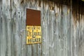 Rustic grey barn siding with metal signs.