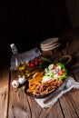 A Rustic gyros plate it green salad and potato wedges