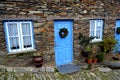 Rustic hand-hewn wood door set into a stone wall built from schist in PiodÃÂ£o, made of shale rocks stack, one of Portugal's schist