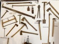Rustic hand tools collection arranged on white wall in ethnographic exhibit Royalty Free Stock Photo