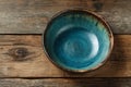 Rustic handmade ceramic bowl with turquoise glaze sitting on a wooden table Royalty Free Stock Photo
