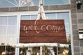 Rustic Handmade Wood Welcome Sign with Room for Text Outside of Fancy Venue with Elegant Windows
