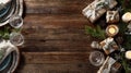 Rustic holiday table setting with gift boxes, candles, and natural decor on wooden surface Royalty Free Stock Photo