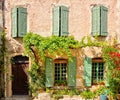 House front with shuttered windows and leafy facade, Provence, France