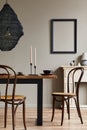 Rustic interior design of dining room with wooden family table, candlestick, retro chair, cup of coffee, decoration.