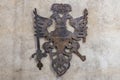 Rustic iron eagle emblem mounted on concrete wall. March 22, 2025, Kutna Hora, Czech Republic Royalty Free Stock Photo