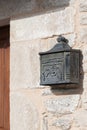 Rustic iron mailbox on a stone wall.
