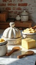 Rustic kitchen arrangement with butter dish and cheese in sunlight Royalty Free Stock Photo