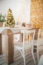 Rustic kitchen and living room interior decorated for Christmas. New Year`s interior of the Scandinavian style. Textural light roo Royalty Free Stock Photo