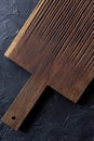 Rustic kitchen utensils concept. Empty dark ribbed oak board on black background top view