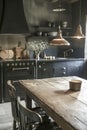 Rustic kitchen, wooden table, black cabinetry, copper lighting, cozy atmosphere, decorative items, dark chairs, built-in oven, Royalty Free Stock Photo