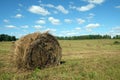 Rustic landscape with summer field with many rolled haystacks with one of it close-up