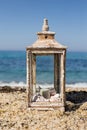 Rustic lantern with candle and seashells by the seaside Royalty Free Stock Photo