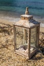 Rustic lantern with candle and seashells by the seaside Royalty Free Stock Photo