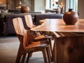 Rustic live edge dining table and solid wood chairs close up. Organic interior design of modern living room in farmhouse