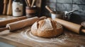 Rustic artisan bread with rolling pins and flour on wooden countertop sourdough baking Royalty Free Stock Photo