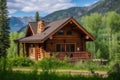 rustic log cabin house surrounded by trees, with view of the mountains in the background Royalty Free Stock Photo