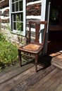 Sunlit antique chair on the porch of a log cabin