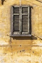 Rustic louvred window shutters and yellow wall Royalty Free Stock Photo