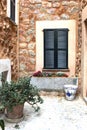 Rustic Mediterranean patio with flowerpots and shutters Royalty Free Stock Photo