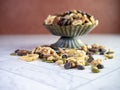 Rustic Metal raised dish filled with healthy trail mix loaded with peanuts, walnuts, granola, dried cranberry, chocolate chips,