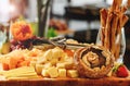 Rustic mix of cheese cuts, mushrooms and fruits on a wooden platter, during brunch buffet. Tasty assortment of fresh cheese Royalty Free Stock Photo