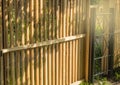 Rustic new wooden fence with black metal posts and gates, garden and vegetable garden fence on a Sunny summer day, against the Royalty Free Stock Photo