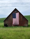 Rustic old barn with American Flag hanging on the side Royalty Free Stock Photo