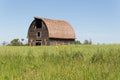 rustic old barn sitting in a green field in summer