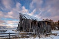 Rustic old Barn in winter with clouds that are painted with the colors on morning