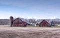 Rustic old barns in early spring before fields are plowed Royalty Free Stock Photo