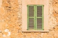 Rustic old green window shutter with vintage stone wall Royalty Free Stock Photo